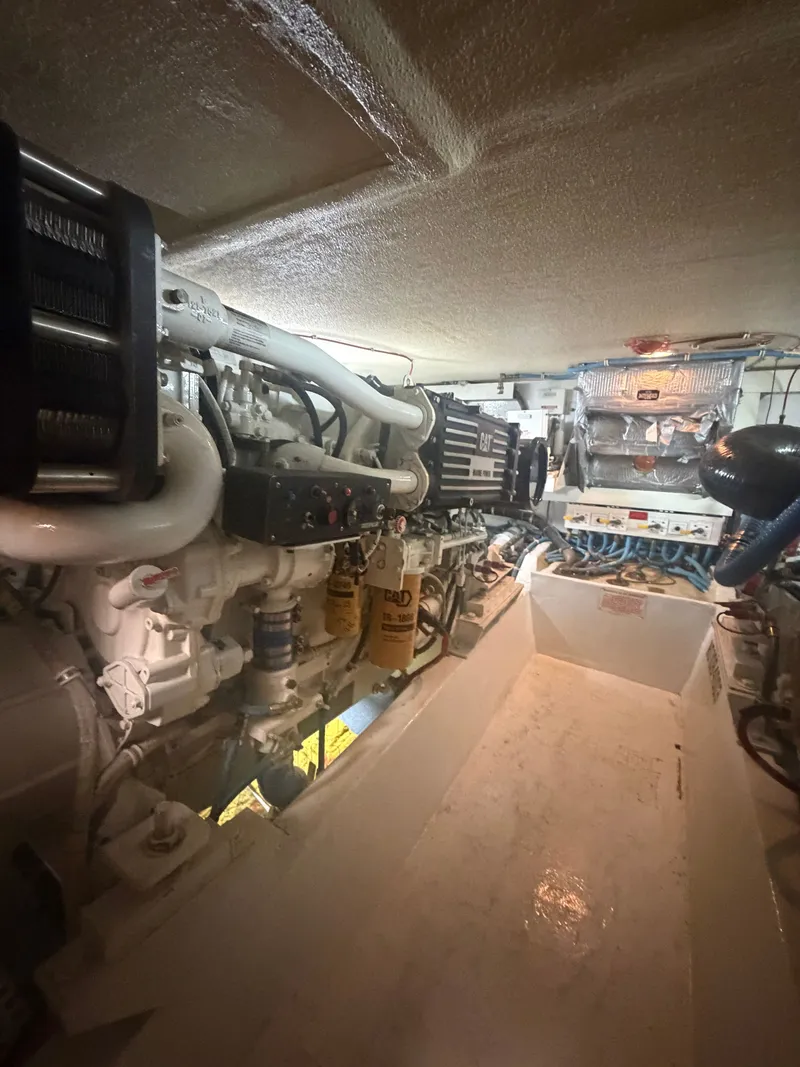 Slide: The Image of The engine room of a 1999 Hatteras 52 Cockpit Motor Yacht with visible machinery and equipment. - 29