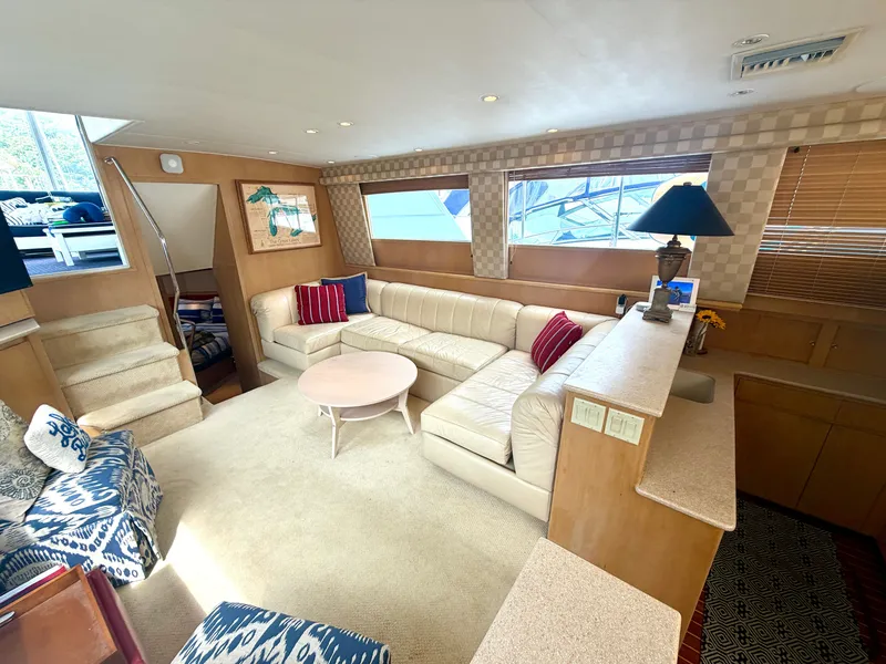 Slide: The Image of Interior of a 1999 Hatteras 52 Cockpit Motor Yacht with beige sofa and blue cushions. - 18