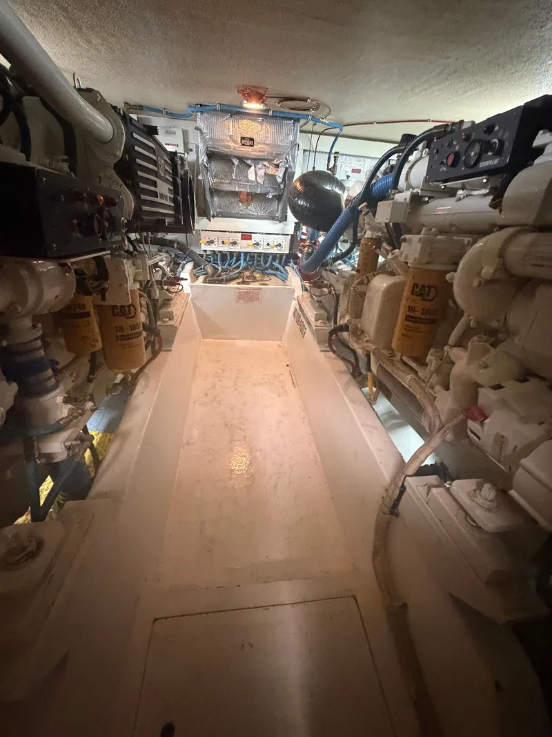 Slide: The Image of Engine room of the 1999 Hatteras 52 Cockpit Motor Yacht with two large engines. - 28