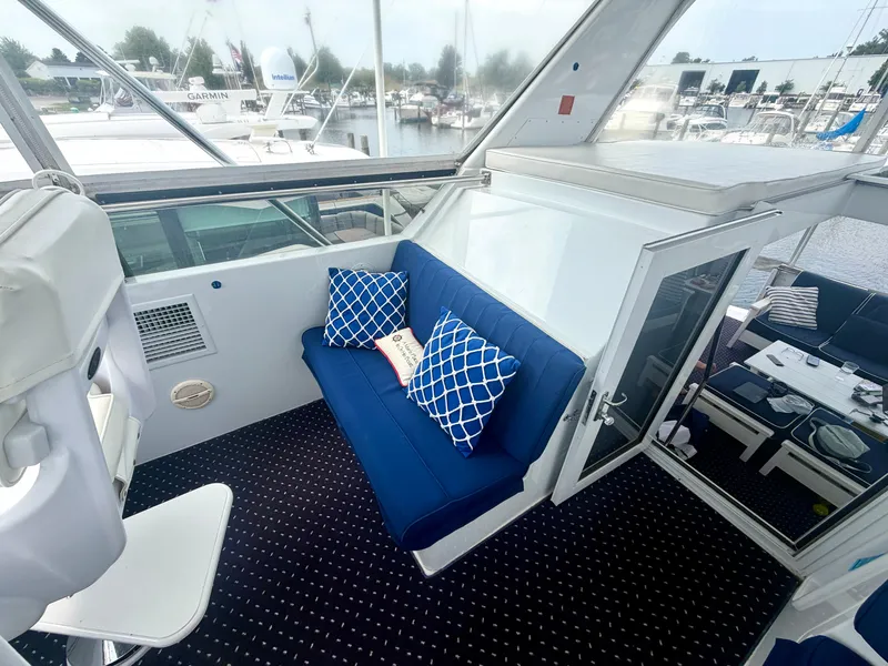 Slide: The Image of The image shows the cockpit of a 1999 Hatteras 52 Cockpit Motor Yacht with blue cushions. - 13