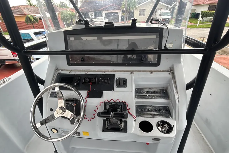 Slide: The Image of 2004 Donzi 29 ZF Open boat dashboard with steering wheel and control panel. - 5