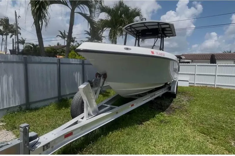 Slide: The Image of 2004 Donzi 29 ZF Open boat on trailer, parked in grassy yard. - 2
