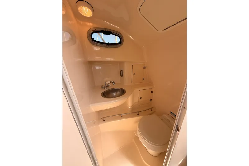 Slide: The Image of 2006 Boston Whaler 285 Conquest boat bathroom with sink, toilet, and storage compartments. - 28