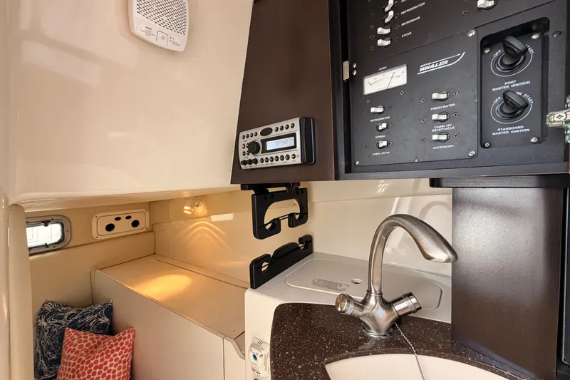 Slide: The Image of 2006 Boston Whaler 285 Conquest cabin interior with control panel and sink. - 23