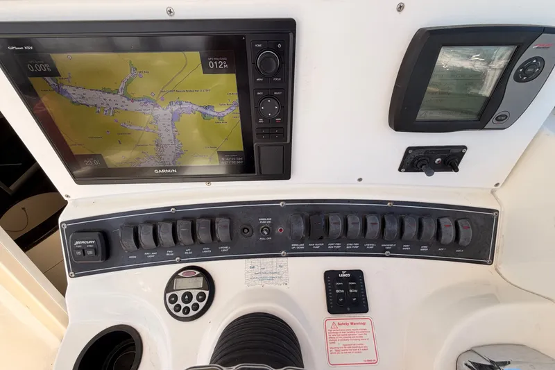 Slide: The Image of Control panel of a 2006 Boston Whaler 285 Conquest with navigation screens and switches. - 14