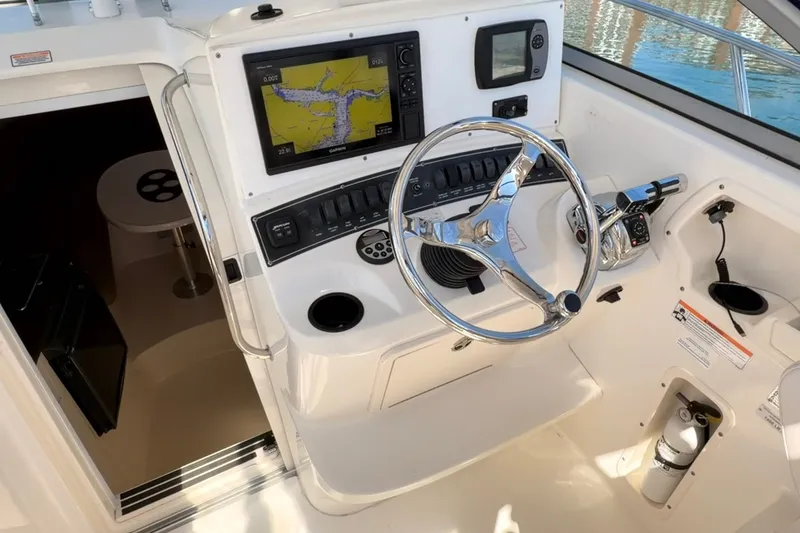 Slide: The Image of 2006 Boston Whaler 285 Conquest helm with navigation system and steering wheel. - 13