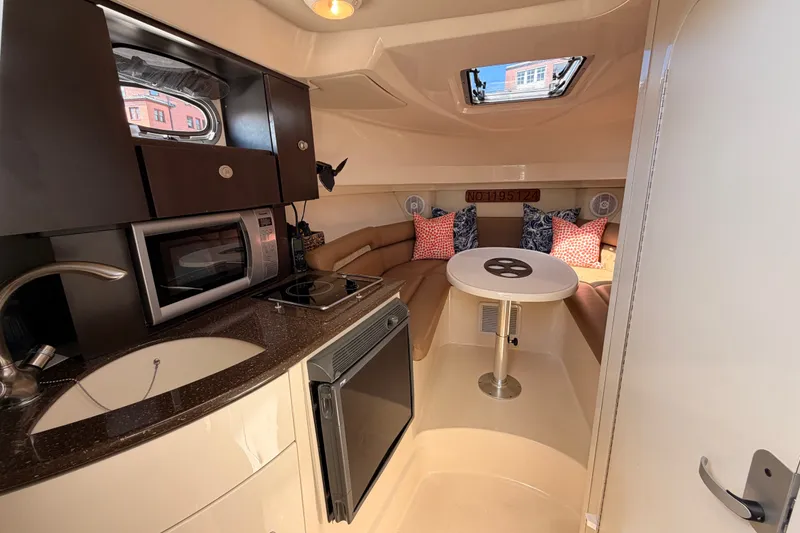 Slide: The Image of Interior of 2006 Boston Whaler 285 Conquest boat with kitchenette and cozy seating area. - 18
