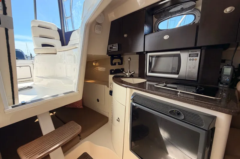 Slide: The Image of Interior of 2006 Boston Whaler 285 Conquest, featuring kitchenette with microwave and sink. - 22