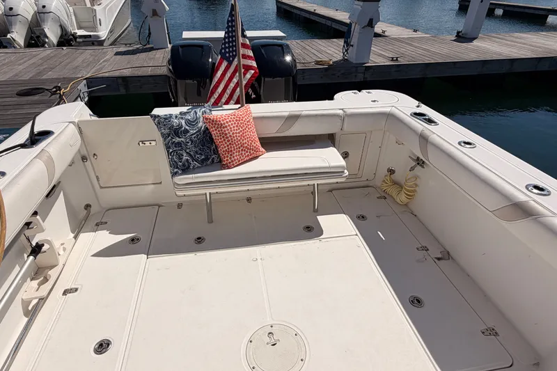 Slide: The Image of 2006 Boston Whaler 285 Conquest boat deck with seating, cushions, and American flag. - 17