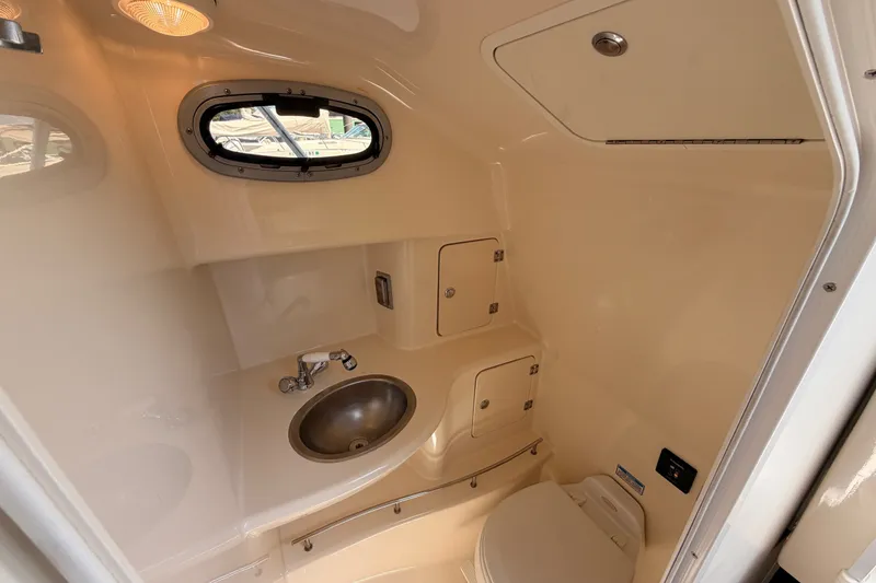 Slide: The Image of 2006 Boston Whaler 285 Conquest boat bathroom with sink, toilet, and storage compartments. - 29