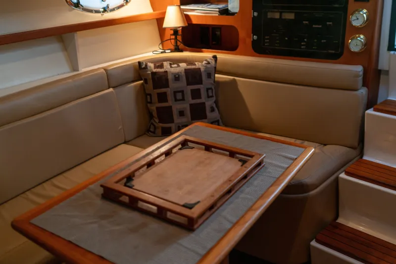 Slide: The Image of Interior of 2001 Tiara Yachts 3100 Open, featuring cozy seating and elegant wooden table. - 20