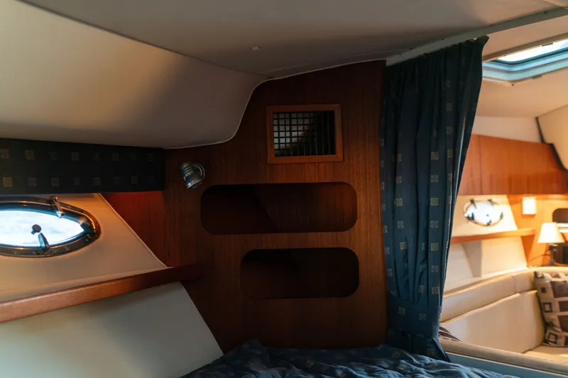 Slide: The Image of Interior cabin of 2001 Tiara Yachts 3100 Open, featuring wood paneling and cozy seating. - 22