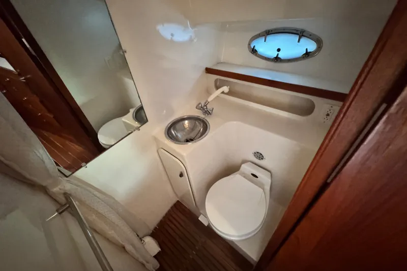 Slide: The Image of 2001 Tiara Yachts 3100 Open bathroom with sink, toilet, and porthole window. - 18