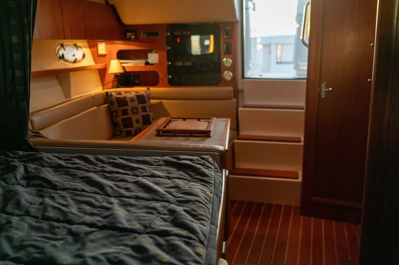 Slide: The Image of Interior of 2001 Tiara Yachts 3100 Open, featuring cozy seating and elegant wood finishes. - 21