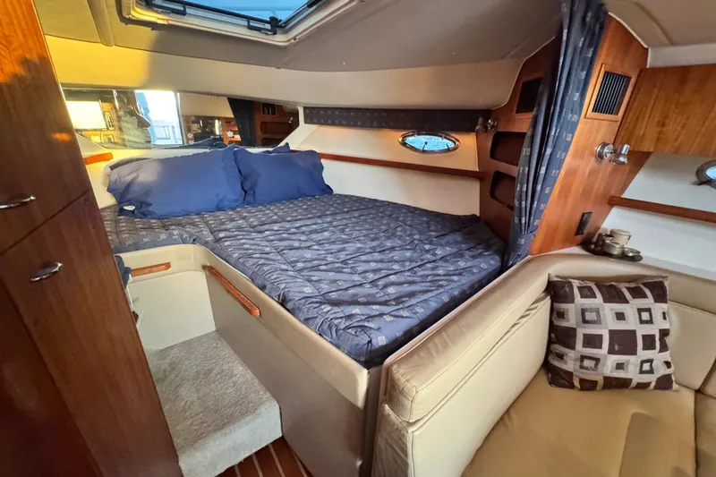Slide: The Image of Luxurious cabin interior of 2001 Tiara Yachts 3100 Open with cozy bedding and elegant decor. - 16