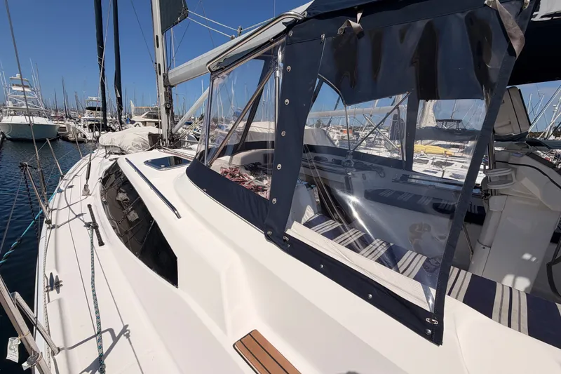 Slide: The Image of 2009 Hunter 50 Center Cockpit sailboat docked at marina, featuring clear cockpit enclosure. - 19