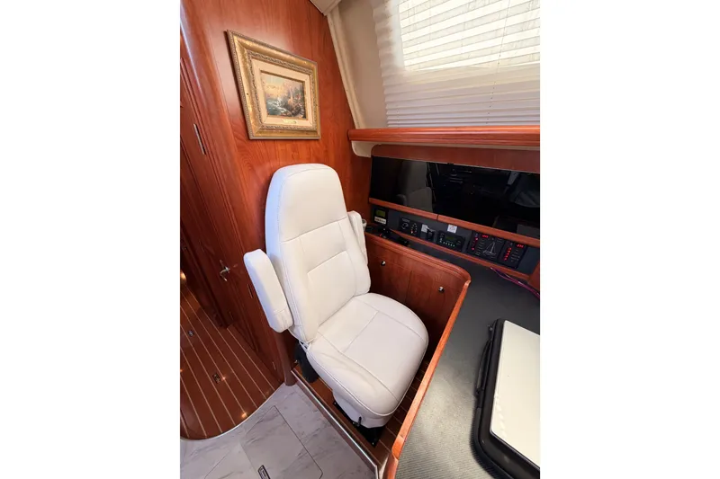 Slide: The Image of Luxurious interior of 2009 Hunter 50 Center Cockpit with white seating and wood paneling. - 49