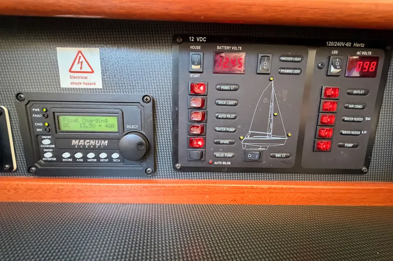 Slide: The Image of Electrical control panel of a 2009 Hunter 50 Center Cockpit sailboat, showing voltage and charging status. - 47