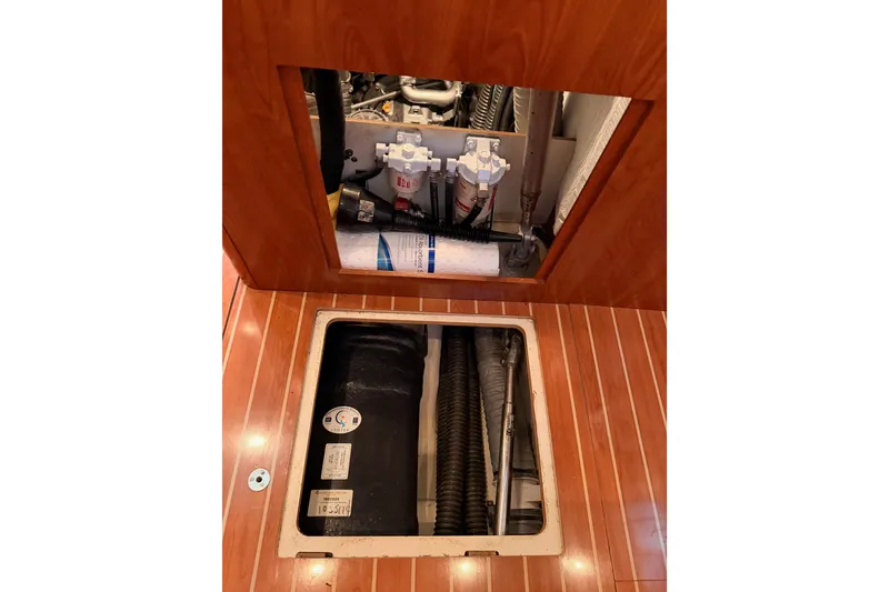 Slide: The Image of Engine compartment of 2009 Hunter 50 Center Cockpit sailboat with visible components and hoses. - 108