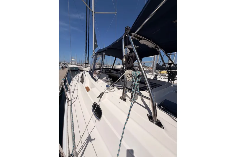 Slide: The Image of 2009 Hunter 50 Center Cockpit sailboat docked, showcasing deck and rigging under clear blue sky. - 18