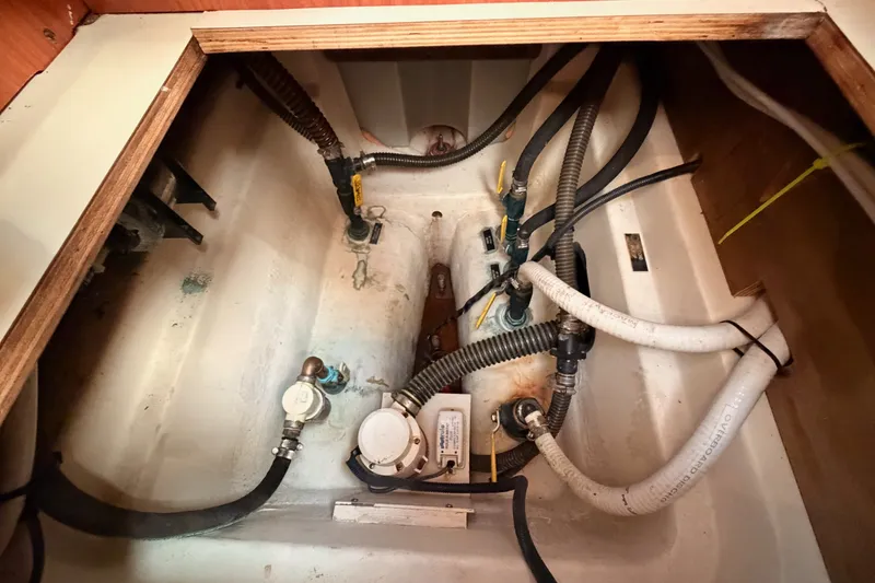 Slide: The Image of Bilge area of a 2009 Hunter 50 Center Cockpit sailboat with visible hoses and fittings. - 109
