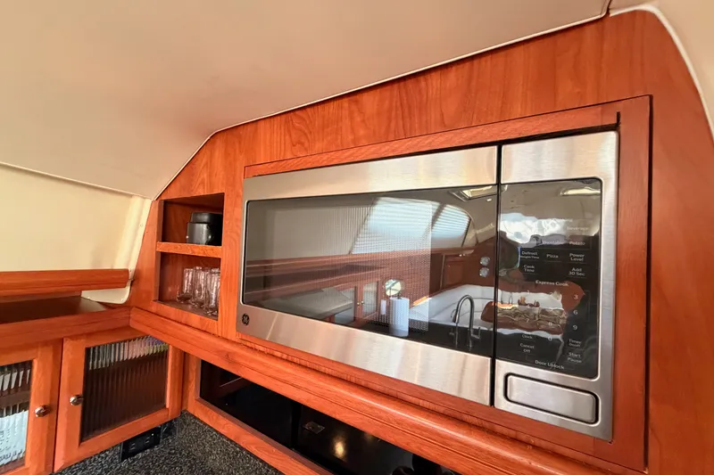 Slide: The Image of Interior of 2009 Hunter 50 Center Cockpit yacht featuring a modern microwave and wooden cabinetry. - 54