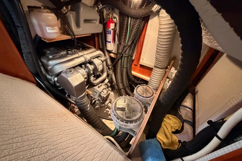 Slide: The Image of Engine compartment of a 2009 Hunter 50 Center Cockpit sailboat, featuring hoses and equipment. - 102