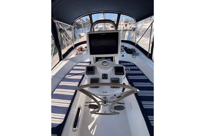 Slide: The Image of 2009 Hunter 50 Center Cockpit interior with navigation equipment and striped seating. - 30
