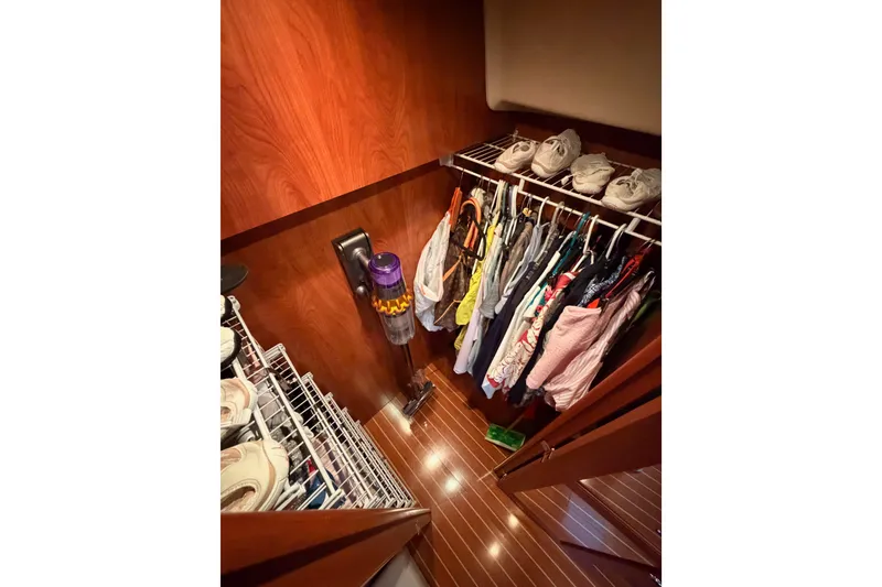 Slide: The Image of Closet interior on 2009 Hunter 50 Center Cockpit yacht with clothes and shoes neatly organized. - 94