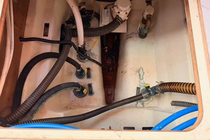 Slide: The Image of Engine compartment of a 2009 Hunter 50 Center Cockpit sailboat with visible hoses and fittings. - 113