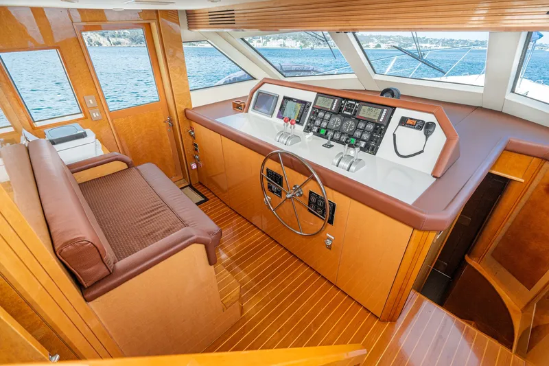 Slide: The Image of 1996 Hatteras 70 Sport Deck Motor Yacht helm with wood finish and modern controls. - 42