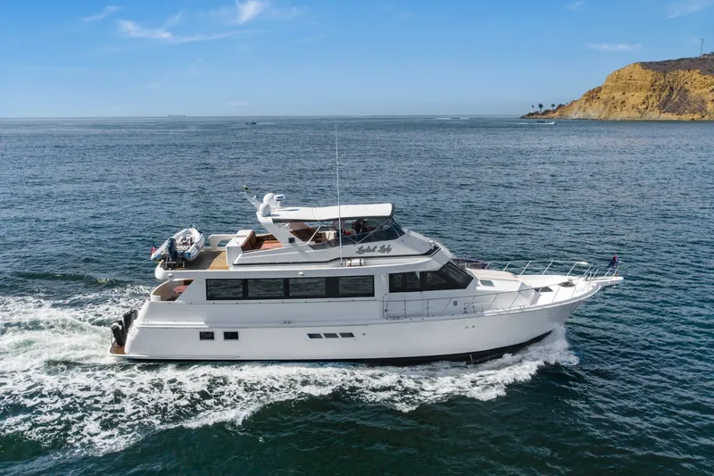 Slide: The Image of 1996 Hatteras 70 Sport Deck Motor Yacht cruising on open water. - 11