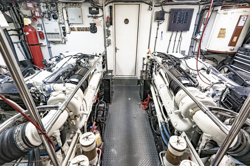 Slide: The Image of Engine room of 1996 Hatteras 70 Sport Deck Motor Yacht, featuring dual engines and control panels. - 68