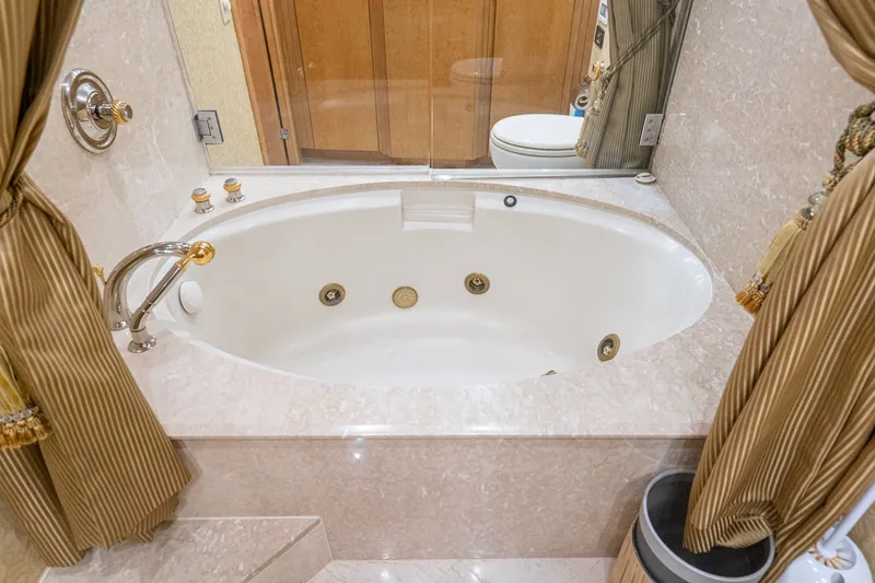 Slide: The Image of Luxurious bathroom with oval bathtub on 1996 Hatteras 70 Sport Deck Motor Yacht. - 57