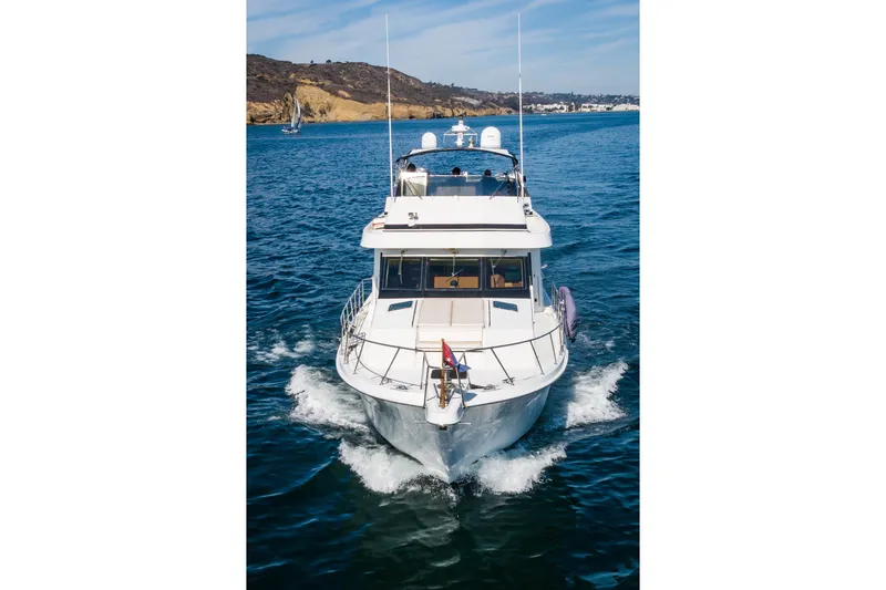 Slide: The Image of Front view of a 1996 Hatteras 70 Sport Deck Motor Yacht cruising on the ocean. - 10