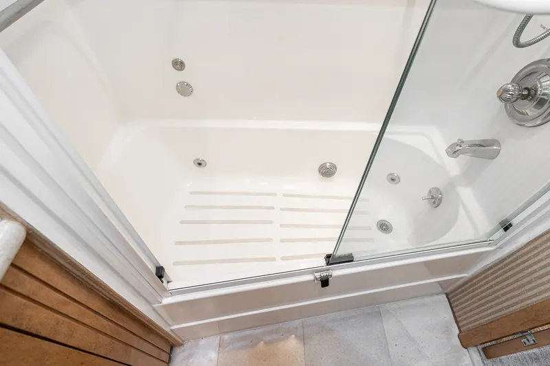 Slide: The Image of Shower area in 1996 Hatteras 70 Sport Deck Motor Yacht with glass door and chrome fixtures. - 65