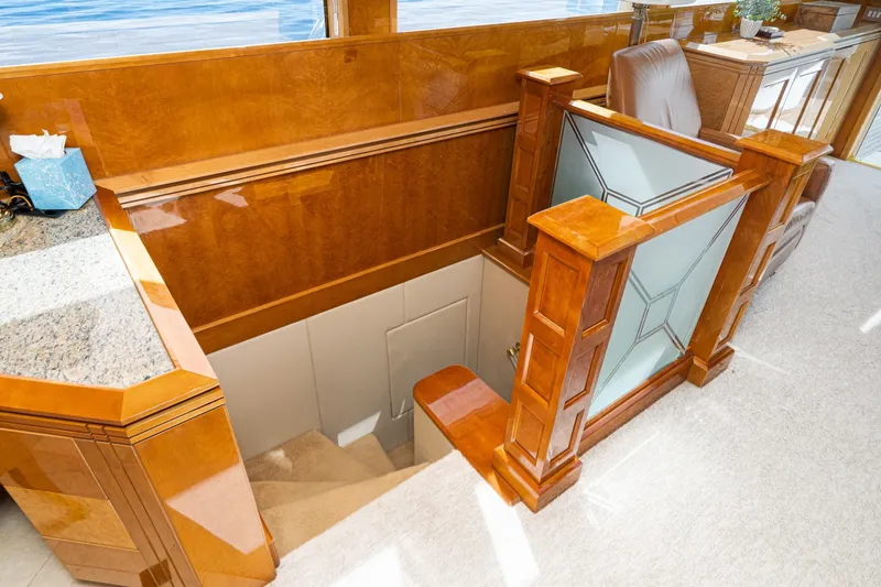Slide: The Image of Luxurious interior of 1996 Hatteras 70 Sport Deck Motor Yacht with elegant wood finish and staircase. - 53