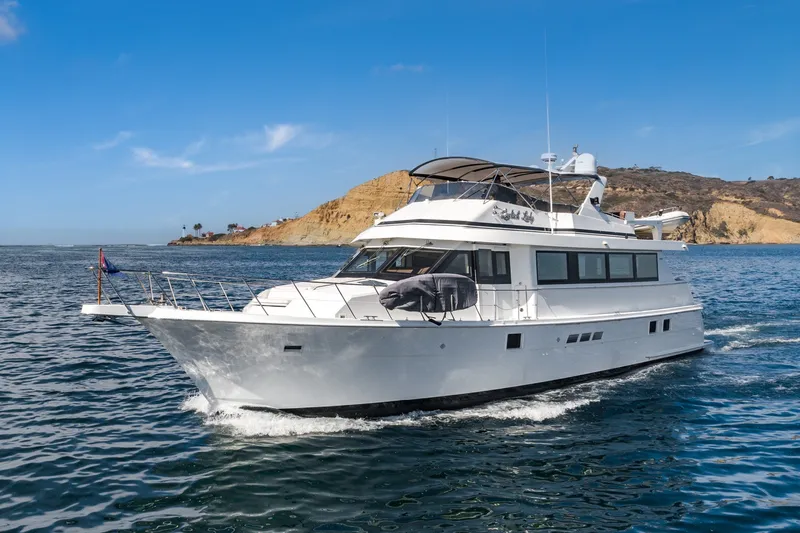 The Image of 1996 Hatteras 70 Sport Deck Motor Yacht cruising near rocky coastline. - 1