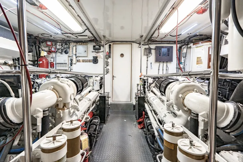 Slide: The Image of Engine room of 1996 Hatteras 70 Sport Deck Motor Yacht, featuring dual engines and control systems. - 67