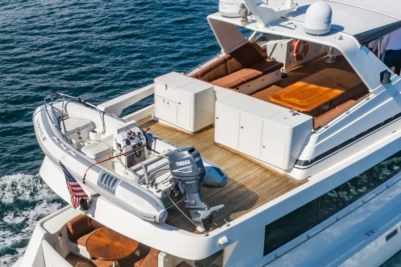 Slide: The Image of 1996 Hatteras 70 Sport Deck Motor Yacht with tender on deck, cruising on open water. - 7