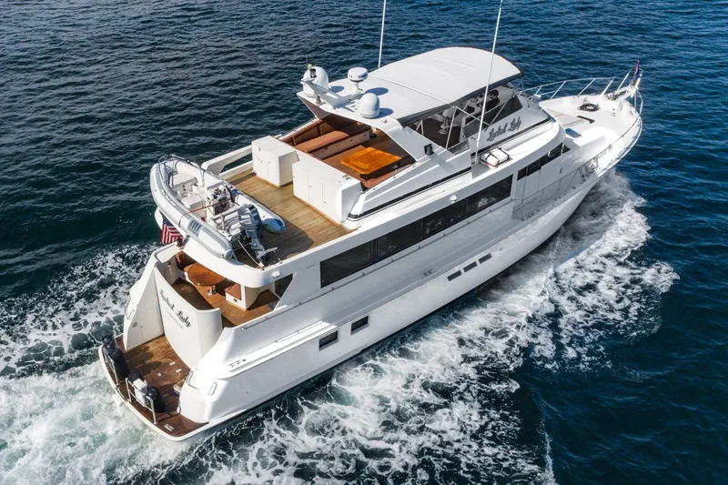 Slide: The Image of 1996 Hatteras 70 Sport Deck Motor Yacht cruising on open water. - 12