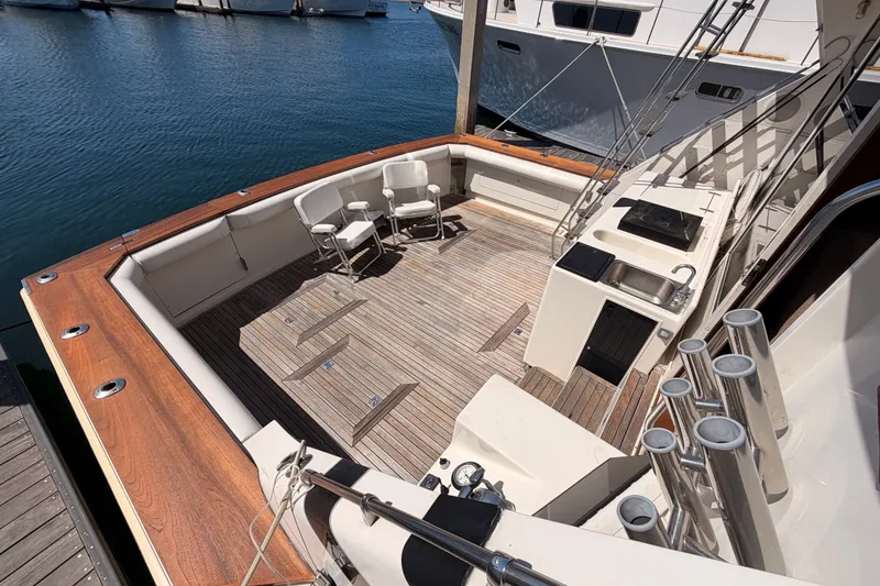 Slide: The Image of 1982 Bertram 54 Convertible yacht deck with seating and fishing rod holders. - 26