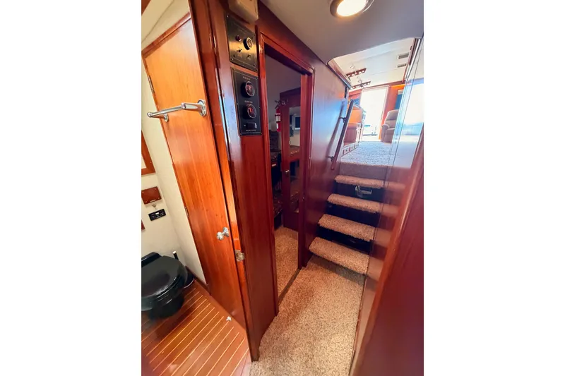 Slide: The Image of Interior of 1982 Bertram 54 Convertible yacht with wooden paneling and carpeted stairs. - 84