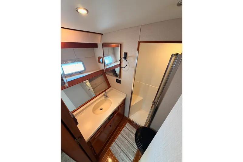 Slide: The Image of Interior of 1982 Bertram 54 Convertible yacht bathroom with sink, mirror, and shower. - 80