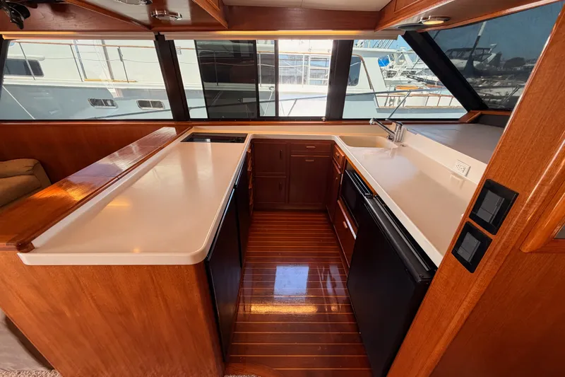 Slide: The Image of Luxurious kitchen interior of 1982 Bertram 54 Convertible yacht with wood accents and modern appliances. - 55