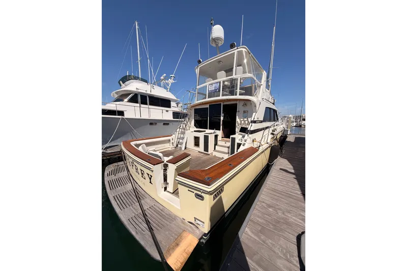 Slide: The Image of 1982 Bertram 54 Convertible yacht docked at marina under clear blue sky. - 14