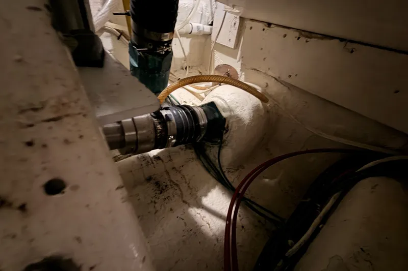 Slide: The Image of Engine room of a 1982 Bertram 54 Convertible boat, showing mechanical components and wiring. - 99