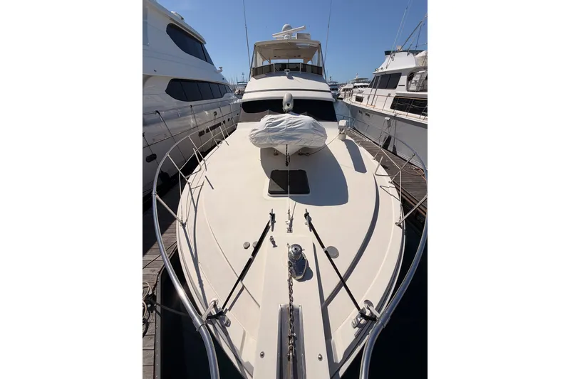 Slide: The Image of 1982 Bertram 54 Convertible yacht docked, showcasing sleek design and spacious deck. - 24