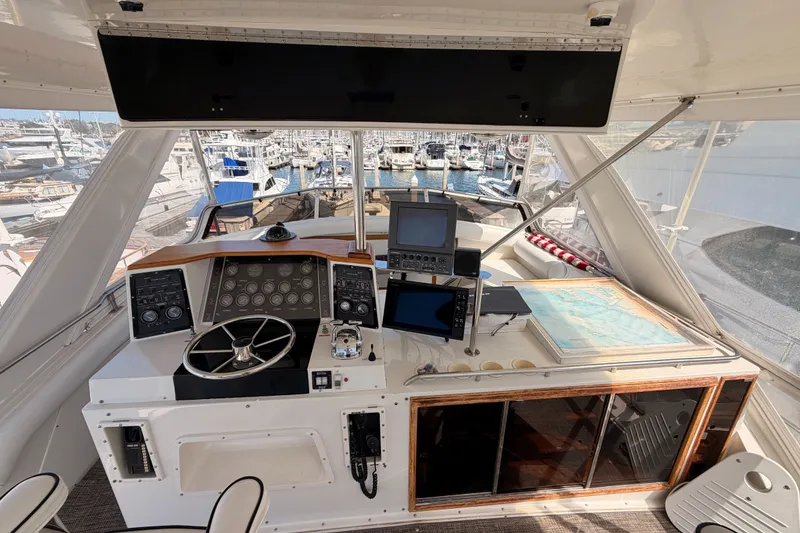 Slide: The Image of Cockpit of 1982 Bertram 54 Convertible yacht with navigation equipment and marina view. - 28