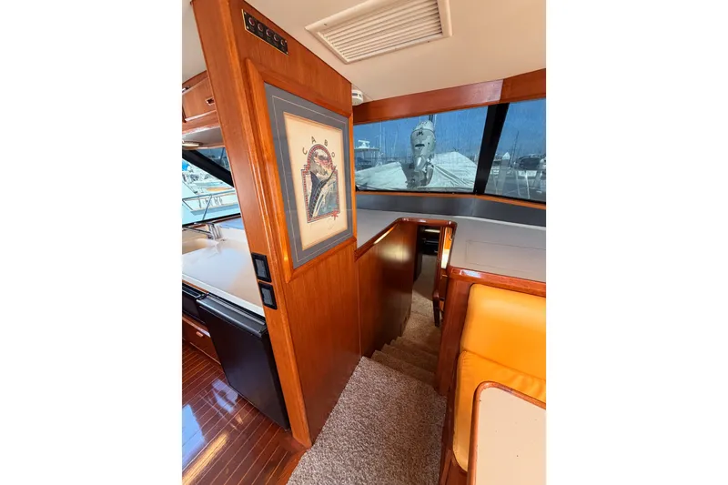 Slide: The Image of Interior of 1982 Bertram 54 Convertible yacht with wood paneling and nautical artwork. - 61